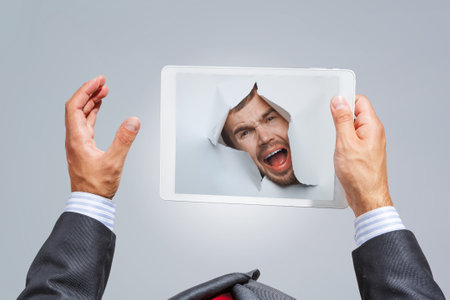 Male face through the hole in paper