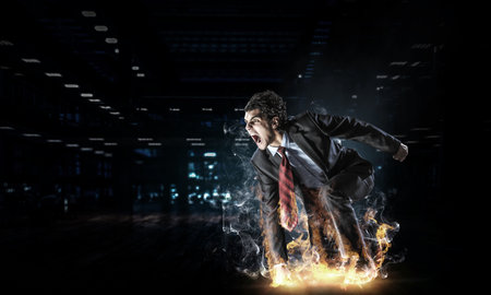 Determined businessman leaving fire trails on asphaltの写真素材