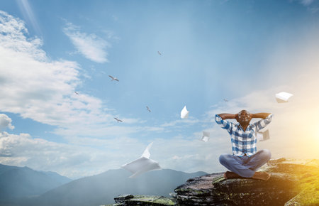 Young black man sitting and meditatingの写真素材