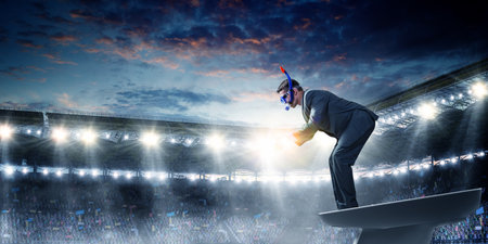 Young businessman in suit ready to diveの写真素材