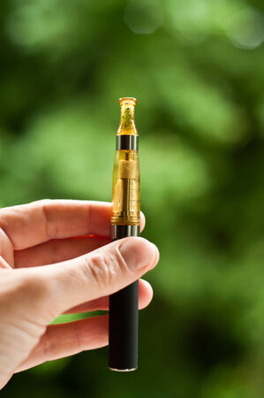 e-cigarette with hand closeup in outdoorの写真素材