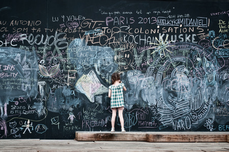 little girl writing on big blackboardの写真素材