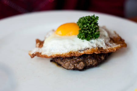 steak with egg and parsley in restaurantの写真素材