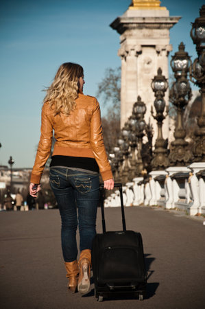 PARIS - France - 16 January 2012 - blond woman with suitcase on Alexandre III bridgeのeditorial素材