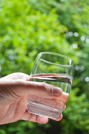 glass in hand in outdoorの写真素材