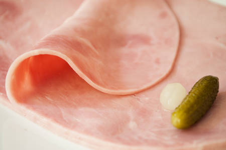 sliced ham with decorative gherkin and onionの写真素材