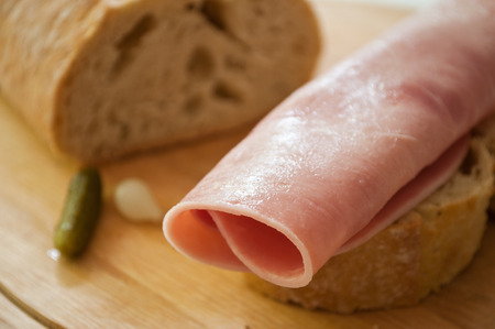 sliced ham and country bread with decorative gherkin and onionの写真素材