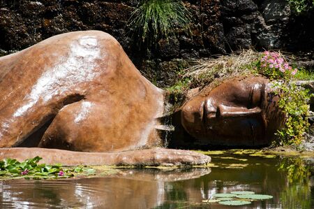 statue of buddha in the water in japanese gardenの写真素材