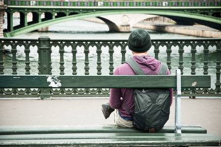 man sitting on bench in front of Seine river in Parisの写真素材