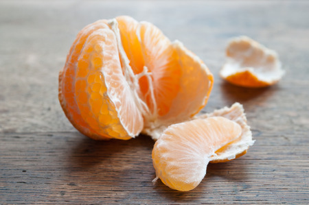 peeled  tangerine on wooden backgroundの写真素材