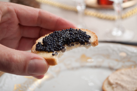 closeup of lumpfish roe in hand at restaurantの写真素材