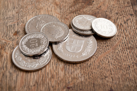 Coins of Switzerland on wooden desk