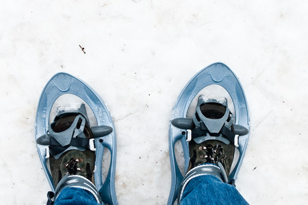 closeup of legs with blue jean and snowshoesの写真素材