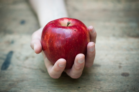 red apple temptation concept on wooden table
