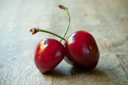 closeup of cherries on wooden table background