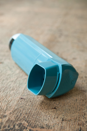 closeup of asthma aerosol on wooden table backgroundの写真素材