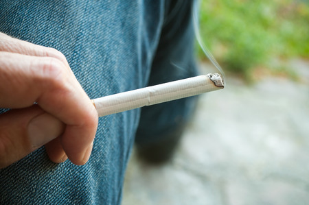 closeup on hand of man with cigarette in outdoorの写真素材