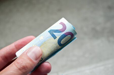 closeup of wad of cash of twenty euros in hand
