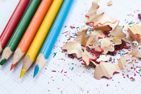 coloring pencils and pencil shavings on notebook backgroundの写真素材