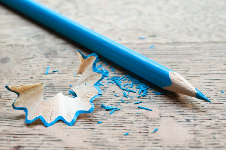 blue pencil and shavings on wooden backgroundの写真素材