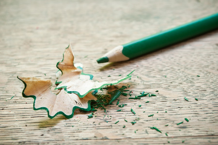 green pencil and shavings on wooden backgroundの写真素材