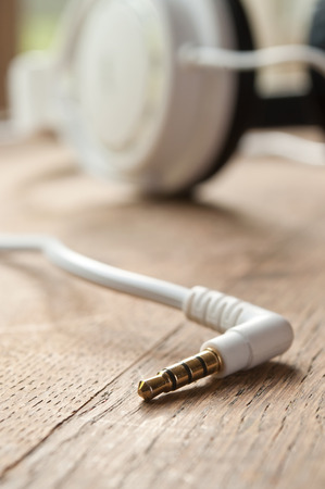 retail of jack cable and headphones  on wooden background