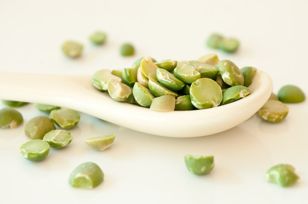 closeup of split peas on a spoon on white backgroundの写真素材