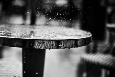 closeup of rain falling on a restaurant table in outdoor