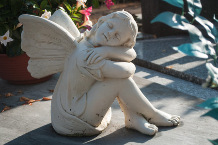 white angel in cemetery on a tombの写真素材
