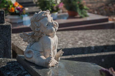 stoned angel in cemetery on a tombの写真素材