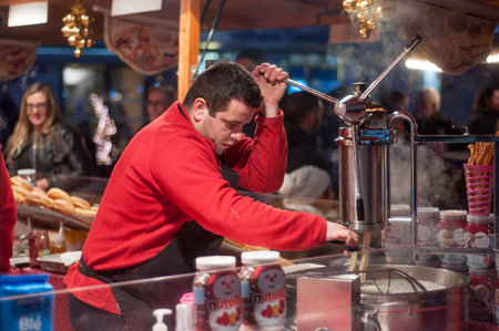 Mulhouse - France - 8 December 2016 - man cutting  churros at the christmas marketのeditorial素材