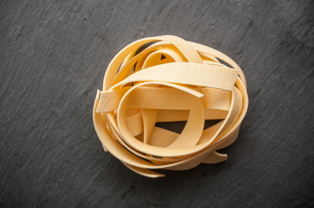 closeup of tagliatelle pasta on chalkboard backgroundの写真素材