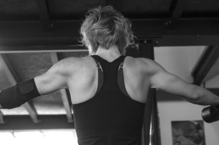retail back of woman with Dumbbells in fitness room 