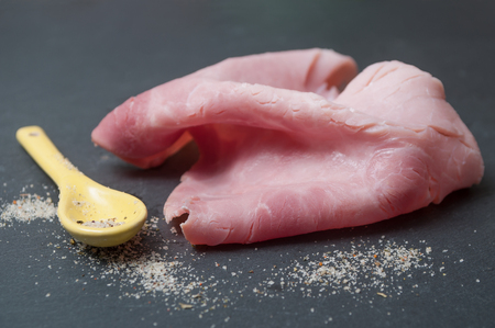 closeup of sliced ham on chalkboard background の写真素材