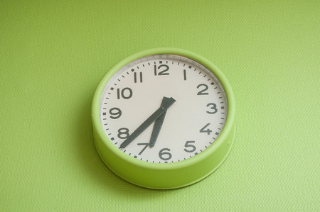 closeup of modern clock on green wall 