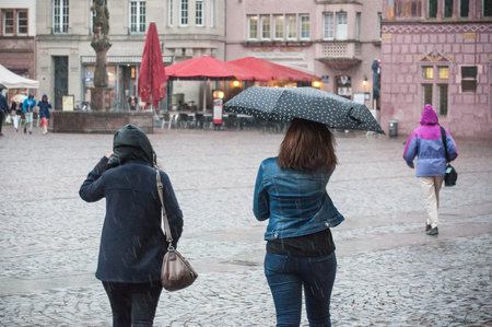 MULHOUSE - France - 13 May 2017 - portrait of women with umbrella on cobbles place in the cityのeditorial素材
