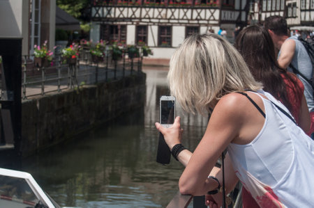 STRASBOURG - France - 25 May 2017 - woman thing a picture with phone at little France quarter in Strasbourgのeditorial素材