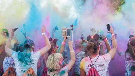 MULHOUSE - France - 4 June 2017 - Closeup of people back Throw powder of color into the air at...