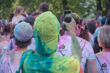MULHOUSE - France - 4 June 2017 - Closeup of people back taking picture with smartphone at Colore Mulhouse 2017, the annual running of five kilometers with colored powder jetsのeditorial素材