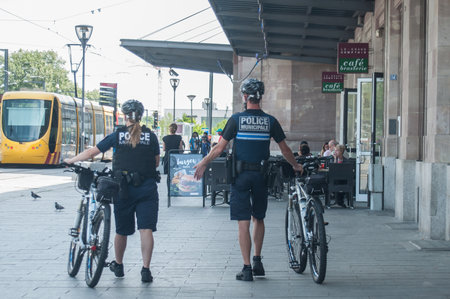MULHOUSE - France - 14 June 2017 - Municipal police patrolling by mountain bike in front of the train stationのeditorial素材
