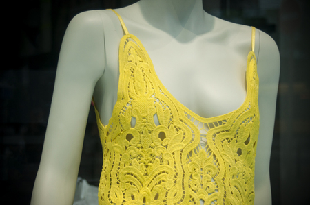 closeup of yellow dress on mannequin in fashion store for women