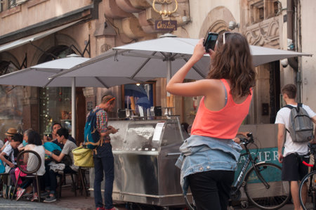 STRASBOURG - France - 1 August 2017 - tourist taking a picture with phone near cathedral of Strasbourgのeditorial素材
