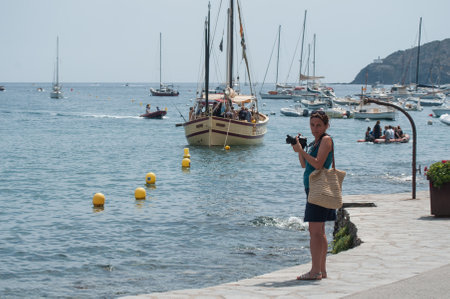 CADAQUES - Spain - 16 August 2017 - tourist taking pictures of sailboats near the coastのeditorial素材