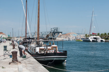 Sete - France - 18 August 2017 - fishers near the beautiful sailboat Moored in the channelのeditorial素材