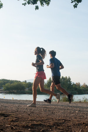 Reiningue - France - 28 August 2017 - couple running in border lakeのeditorial素材