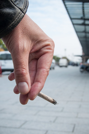 closeup of man hand with cigarette in the streetの写真素材