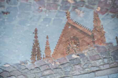 closeup of reflection of the St. Stephen's temple in a puddle in Mulhouseの写真素材
