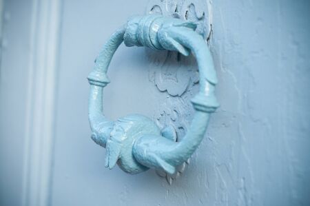 closeup of ancient metallic handle on blue doorの写真素材