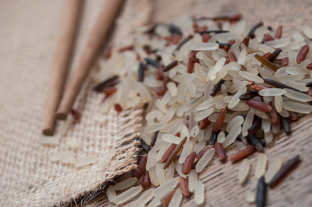 closeup of rice grain and chinese chopsticks on wooden table backgroundの写真素材