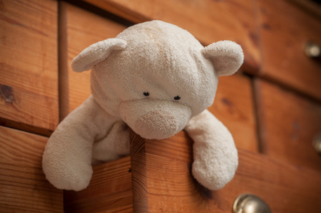 closeup of reddy bear on wooden chest of drawers backgroundの写真素材